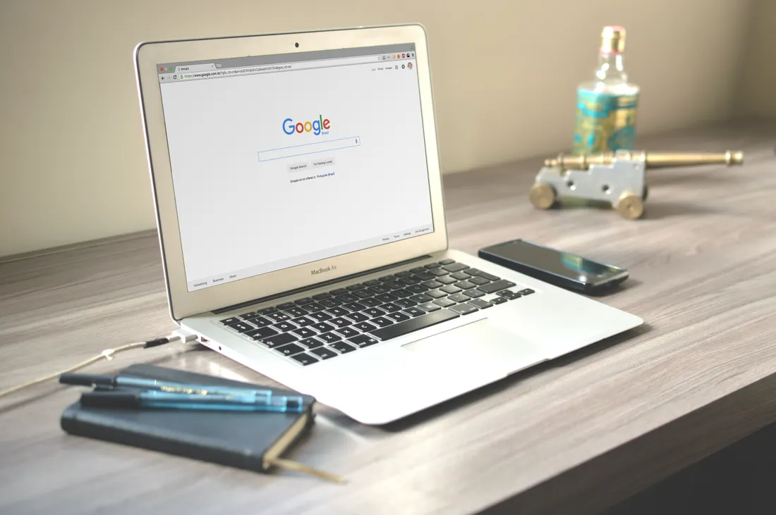 Laptop z otwartą wyszukiwarką na biurku — pozycjonowanie w Google i AI